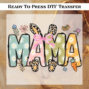 May include: A ready-to-press DTF transfer with the word "MAMA" in a colorful daisy pattern. The letters are outlined in black and have bunny ears and paws.