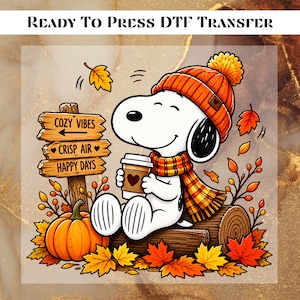 May include: A Ready To Press DTF Transfer featuring a white cartoon dog wearing an orange knit hat and scarf, holding a coffee cup. Beside the dog is a wooden sign with the text Cozy Vibes, Crisp Air, Happy Days, a pumpkin, and autumn leaves.