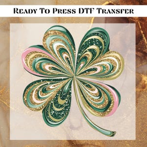 May include: A green four-leaf clover with gold and pink glitter accents. The clover is a digital design for use with a heat press.