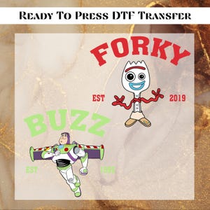 May include: A DTF transfer featuring two cartoon characters, Forky and Buzz Lightyear, with the words "Forky" and "Buzz" in red and green, respectively. The Forky design includes the text "EST 2019". The Buzz Lightyear design includes the text "EST 1995".