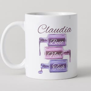 May include: White ceramic mug featuring the name "Claudia" in a script font. Below the name are three stacked nail polish bottles in shades of purple and pink, with the words "Best Nail Tech".
