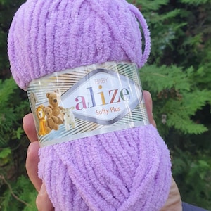 May include: A ball of purple yarn labeled "Baby Alize Softy Plus" with a teddy bear illustration on the label.