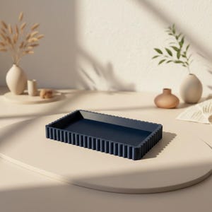 Könnte beinhalten: Ein rechteckiges, marineblaues Tablett mit einem geriffelten, gerippten Randdesign. Das Tablett verfügt über eine flache, glatte Innenfläche und eine durchgehend einheitliche, dunkelblaue matte Oberfläche, die eine klare geometrische Form bildet.