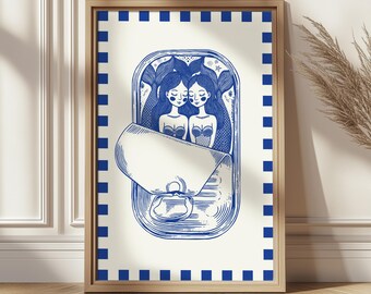 May include: A framed art print featuring a blue and white illustration of two mermaids inside a sardine can. The artwork has a vintage, nautical theme, with a blue checkered border and a wooden frame.