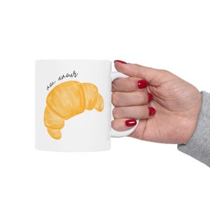 May include: White ceramic mug with a croissant illustration and the text "mon amour" in black script.