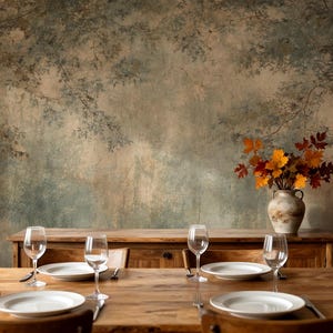 May include: A wooden dining table set for four with white plates, wine glasses, and silverware. A vase of autumn leaves sits on a wooden cabinet against a backdrop of a forest mural.