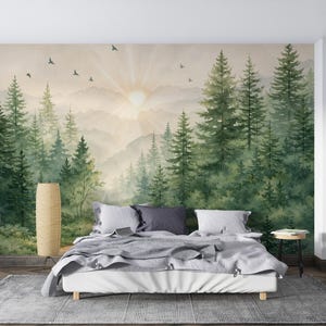 May include: A bedroom with a forest mural depicting a sunrise over mountains and tall green trees. The room includes a bed with grey bedding, a woven floor lamp, and a small side table. Birds are seen flying in the mural.