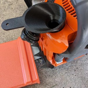 May include: A black 3D printed funnel with a handle attached to an orange chainsaw. The funnel is designed to make it easier to add oil to the chainsaw.