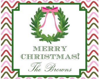 May include: A white Christmas card with a green wreath and a pink bow. The text on the card reads "Merry Christmas! The Browns".