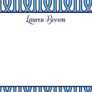 May include: A white card with a blue and white patterned border. The card has a white rectangle in the center with the text "Lauren Brown" in black cursive.