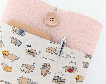 May include: A pink linen book cover with a pocket for a notepad and pen. The cover features a cute cat design with the text "I made you wait".