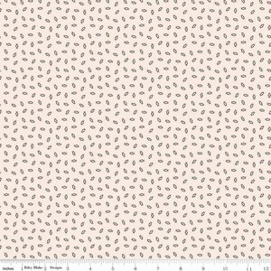 May include: A cream-colored fabric with a repeating pattern of small, dark gray, stylized seed-like shapes. The shapes are scattered across the surface, creating a textured, all-over design. The fabric is measured in inches along the bottom edge.