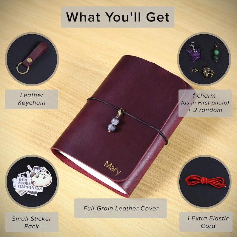 May include: A dark red leather journal with the name Mary engraved on the cover, secured by a black elastic cord with a bead charm. Included are a leather keychain, three metal charms, a sticker pack, and an extra red elastic cord.