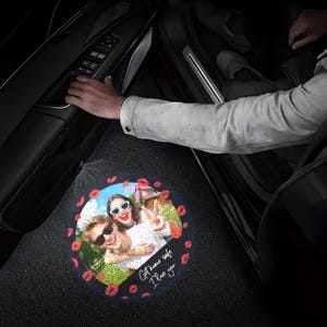 May include: A circular car door puddle light projection on the ground featuring a color photograph of two people wearing sunglasses, surrounded by a border of red lip prints and the white cursive text that reads Get home safe I love you.
