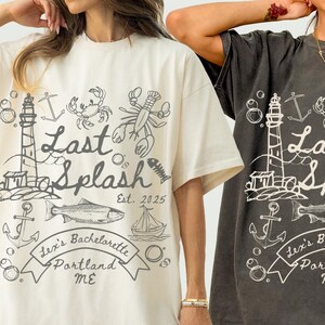 May include: Ivory and pepper-colored t-shirts with a nautical-themed graphic. The design includes a lighthouse, fish, lobster, and the text "Last Splash Est. 2025" and "Lex's Bachelorette Portland ME".