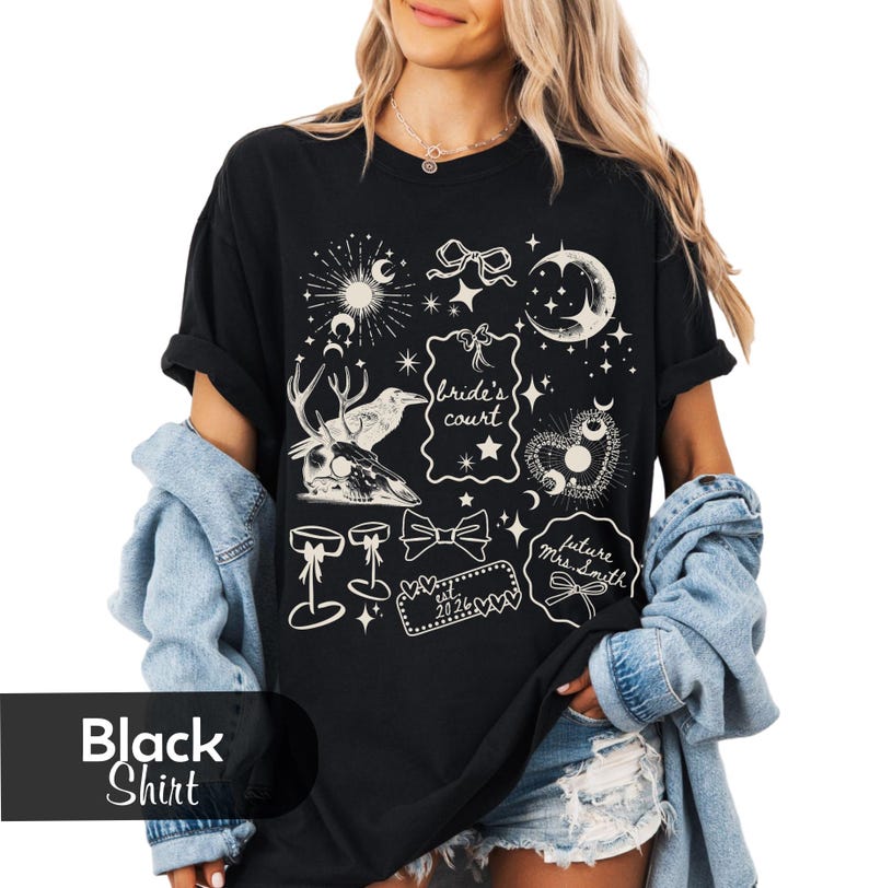 Pu&ograve; includere: Maglietta nera con grafica color crema con elementi celesti e botanici. Il design include lune, stelle, fiocchi e il testo "Bride's Court" e "future Mrs. Smith". La maglietta presenta anche un teschio di cervo e altri elementi decorativi.