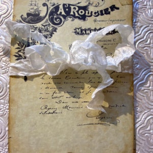 May include: An old, worn, and faded paper document with a decorative border and handwritten text. The text includes the name "A. Rougier" and the words "Graveur Imprimeur" and "Marseilles".
