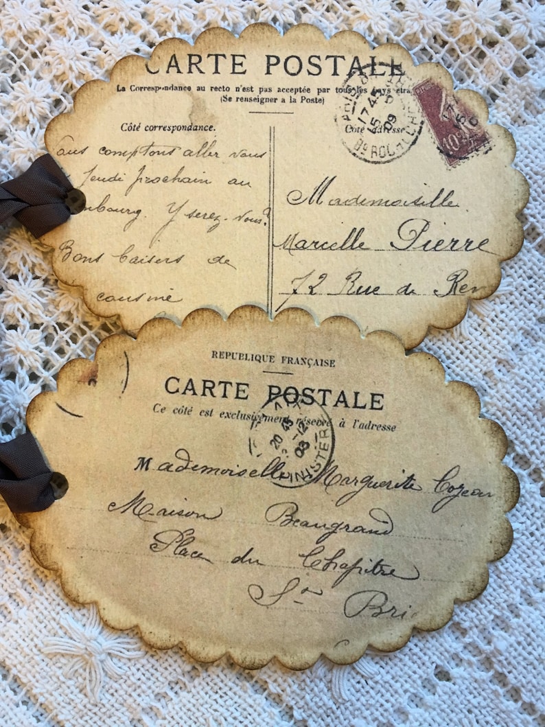 Puede incluir: Dos postales francesas vintage con bordes festoneados y escritura manuscrita. Una tiene un sello y dice "CARTE POSTALE". La otra tiene una cinta adjunta. Las postales est&aacute;n envejecidas con un tono sepia.