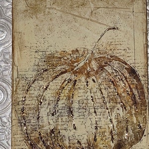 Op de afbeelding: Een rechthoekig label met een vintage pompoenillustratie. De pompoen is bruin en goud met glitteraccenten, tegen een achtergrond van verouderd papier met schrift. Bovenop is een bruin lint bevestigd.