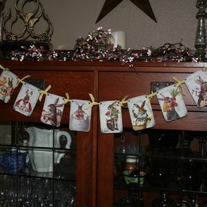 May include: A vintage-style Easter bunny banner with yellow ribbon and a wooden cabinet in the background. The banner features illustrations of bunnies in various poses, including holding carrots and wearing hats.