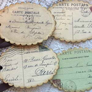 Puede incluir: Cuatro postales de estilo vintage con bordes festoneados y lazos de cinta marr&oacute;n. Las postales presentan escritura manuscrita, sellos y las palabras "CARTE POSTALE" en franc&eacute;s. Las postales son en tonos beige y verde.