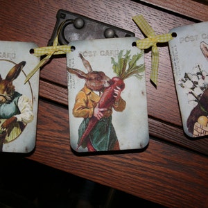 May include: A banner with three vintage postcards featuring illustrations of rabbits. The postcards are decorated with yellow and white gingham ribbon and the text "Post Card".