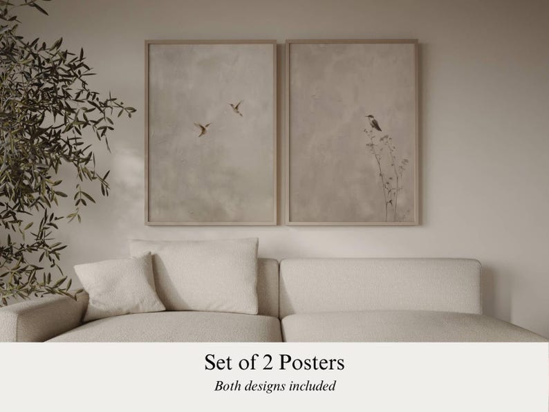 Op de afbeelding: Set van twee ingelijste posters. E&eacute;n poster toont vogels in vlucht, de andere een vogel op een plant. Beide posters hebben een neutraal kleurenpalet en worden boven een cr&egrave;mekleurige bank getoond. De tekst luidt: 'Set of 2 Posters'.