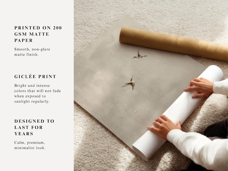 Op de afbeelding: Een persoon rolt een witte matte papieren print met twee kolibrie-illustraties. De print ligt op een lichtgrijze ondergrond, met een bruine papieren rol op de achtergrond. De tekst luidt "GEDRUKT OP 200 GSM MAT PAPIER".