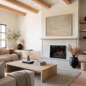 May include: A modern living room with a neutral color palette. Features include a light wood coffee table, a fireplace with a painting above, and a textured rug. The room is decorated with a black vase, books, and a sofa with throw pillows.