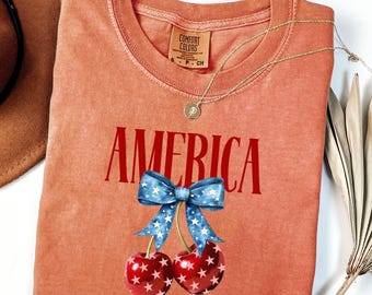 Camiseta Coquette America Cherries, Camiseta Comfort Colors® para o 4 de Julho, Camiseta Patriótica com Laço de Cereja, Camiseta Feminina Moderna para o 4 de Julho