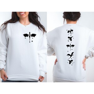 May include: White sweatshirt with a black dragon design on the front and five black dragon designs on the back.