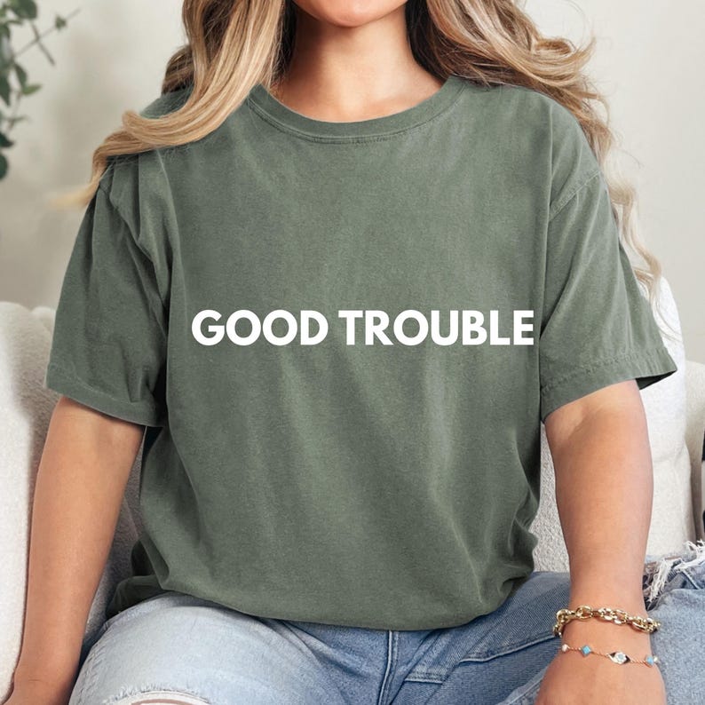 May include: A green t-shirt with the text "GOOD TROUBLE" printed in white on the front.