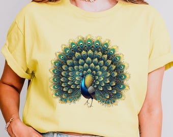 May include: A yellow t-shirt with a peacock design. The peacock has blue and green feathers and is standing with its tail feathers spread out.