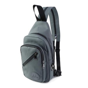 May include: A gray canvas sling bag with black accents and a zippered pocket. The bag has a black adjustable strap and a logo with three mountain peaks.