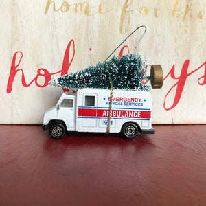 Ambulance Carrying Christmas Tree Ornament