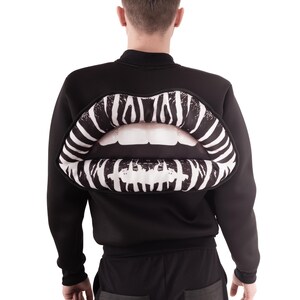 Puede incluir: Sudadera negra con un gran diseño de labios en 3D con estampado de cebra en la espalda.