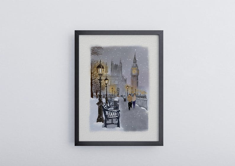 May include: A framed watercolor painting depicts a snowy scene in London. The artwork features Big Ben, street lamps, benches, and two figures walking along a snow-covered path. The painting is set in a black frame.