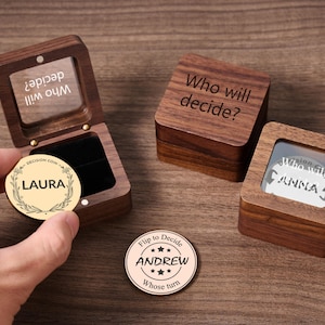 May include: Wooden decision coin boxes and coins with engraved text. One box is open, displaying a coin with "LAURA" and "DECISION COIN". Another box reads "Who will decide?" and a coin says "Flip to Decide ANDREW".