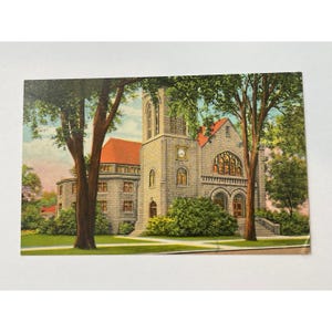 Könnte beinhalten: Vintage Postkarte mit einer Steinkirche mit rotem Dach und einem Glockenturm. Die Kirche hat Bogenfenster und einen großen Eingang. Grüne Bäume umrahmen das Gebäude, und der Himmel ist rosa.