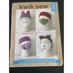 May include: A Kwik Sew pattern for children's accessories, featuring four designs: a cat ear hat, a red headband with a green and white pattern, a purple headband with a panda mask, and a dog ear hat. The pattern is marked "Excess Discontinued".