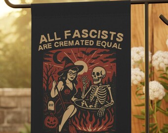 Puede incluir: Bandera de jardín negra con una ilustración de Halloween. El diseño presenta una bruja y un esqueleto, con el texto "ALL FASCISTS ARE CREMATED EQUAL". El fondo incluye un sol naciente, murciélagos y una calabaza.