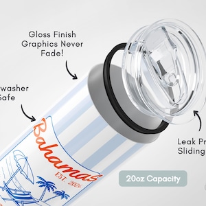 May include: A white and blue striped tumbler with a clear lid. The tumbler features a "Bahamas" graphic with a beach scene. It has a 590ml capacity and a leak-proof sliding lid. The graphics never fade and it is dishwasher safe.