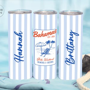 May include: Three insulated stainless steel travel mugs with a blue and white striped design. One mug has the name "Hannah" in blue script, another has a "Bahamas" graphic, and the third has the name "Brittany". The "Bahamas" graphic includes a beach scene.