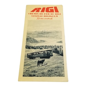 May include: A vintage travel poster for the Rigi Railway in Switzerland. The poster features a red and white logo with the word "Rigi" in large letters. The poster also includes the text "Chemin de Fer du Rigi Vitznau-Rigi Kulm Suisse Centrale". The poster features a black and white image of a train traveling through a mountainous landscape.