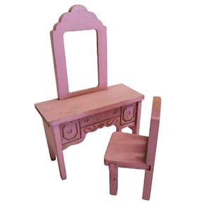 Puede incluir: Un conjunto de tocador de madera rosa con un espejo, una mesa pequeña con cajones y una silla a juego.