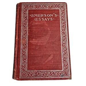 Peut inclure: Un livre ancien intitul&eacute; "Emerson's Essays" avec une couverture rouge et des lettres argent&eacute;es. La couverture pr&eacute;sente une bordure d&eacute;corative argent&eacute;e. Le livre est l&eacute;g&egrave;rement us&eacute;, indiquant son &acirc;ge. Le titre est centr&eacute;.