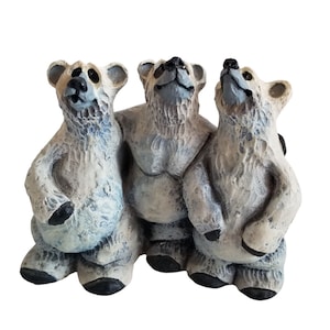May include: Three ceramic polar bear figurines, each with a different pose, looking up. The bears are painted in shades of white, gray, and blue.