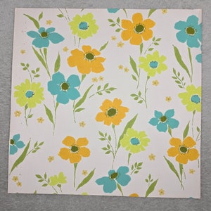 May include: White background wallpaper with a repeating pattern of yellow, green, and blue flowers. The flowers are stylized and have a retro look.