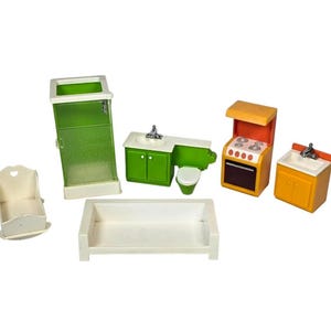 May include: A collection of miniature dollhouse furniture, including a green shower, a white crib, a white bathtub, a green and white bathroom set, an orange and white stove, and an orange and white sink.