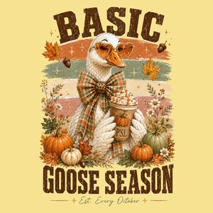 May include: A graphic illustration of a white goose wearing heart-shaped glasses and a plaid bow tie, holding a cup labeled PSL with whipped cream. The design includes pumpkins, autumn leaves, and the text BASIC GOOSE SEASON EST. EVERY OCTOBER.